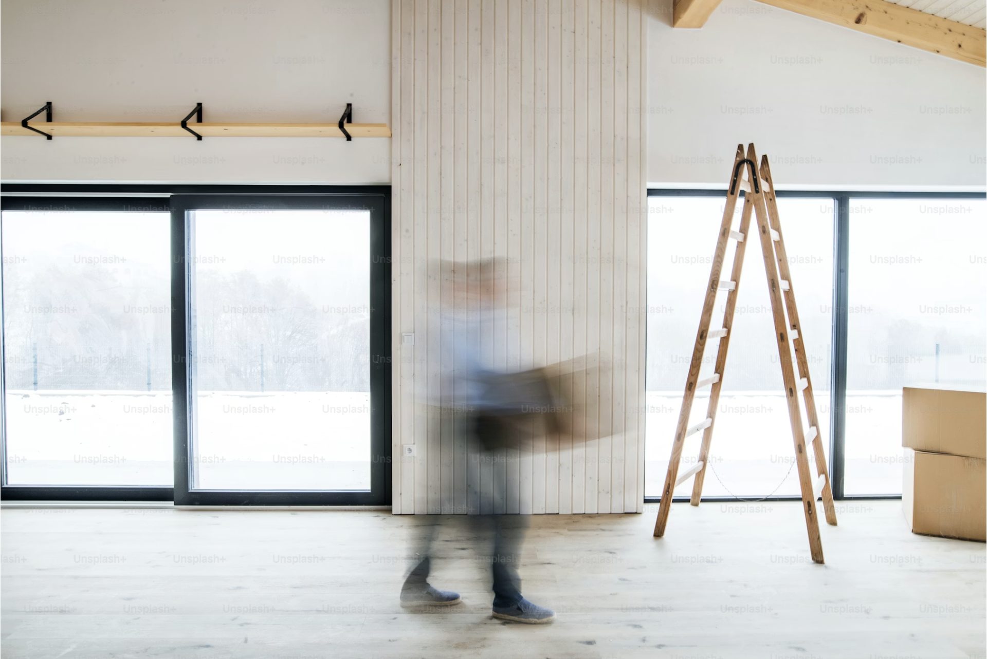 A person moving into a bright Edmonton home with a ladder and boxes