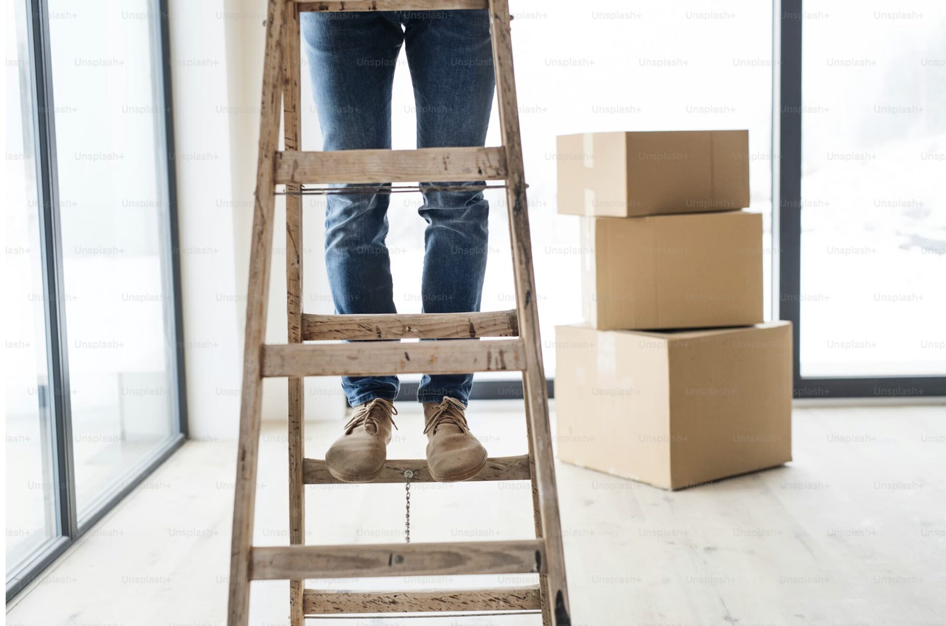 Maintenance technician on a ladder working on an Edmonton rental property