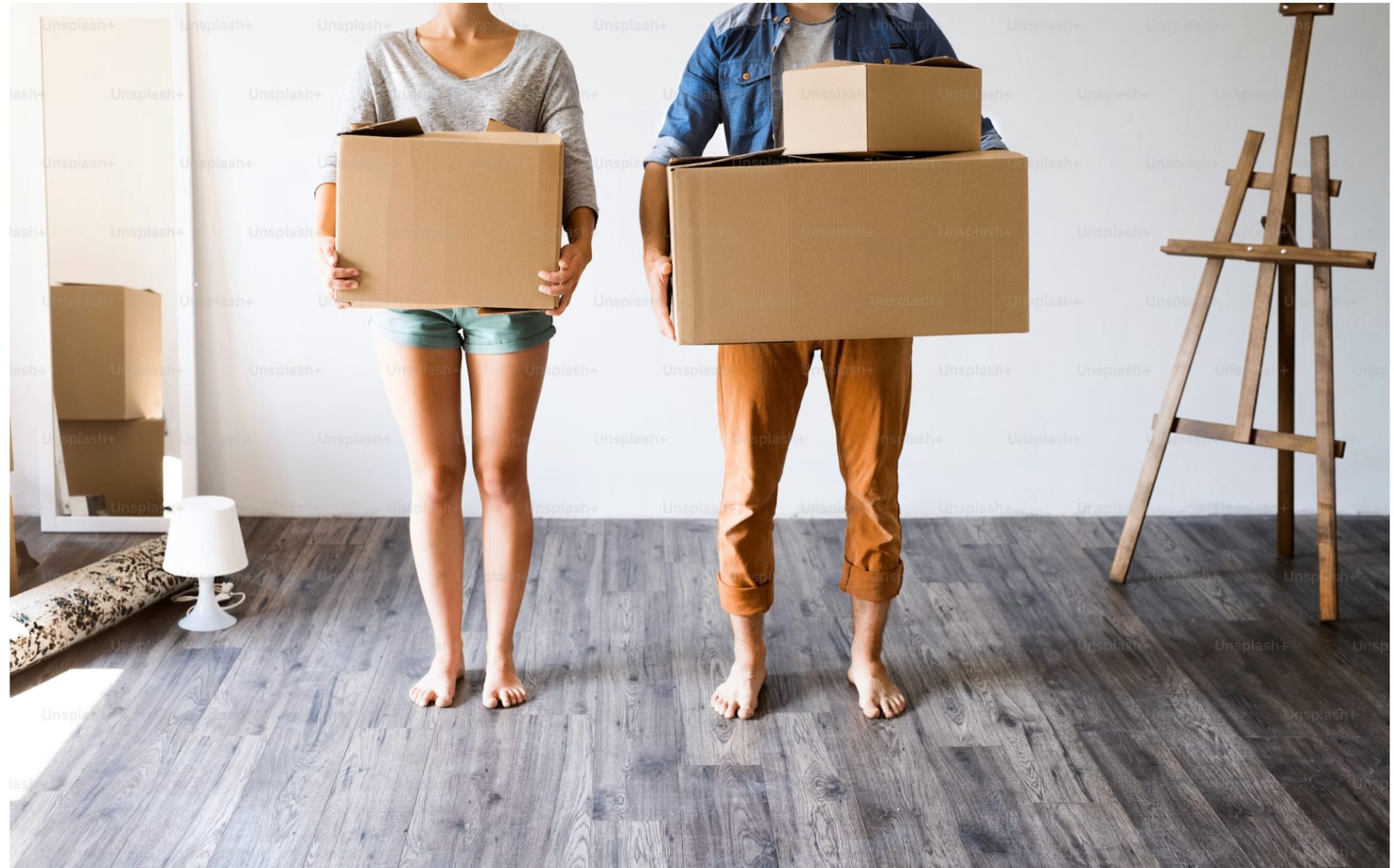 A young couple holding moving boxes in their new Edmonton rental